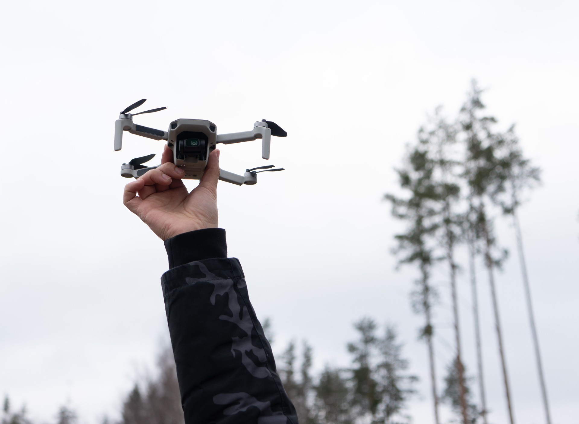 Man launches a quadcopter drone into the air for video and photo shooting